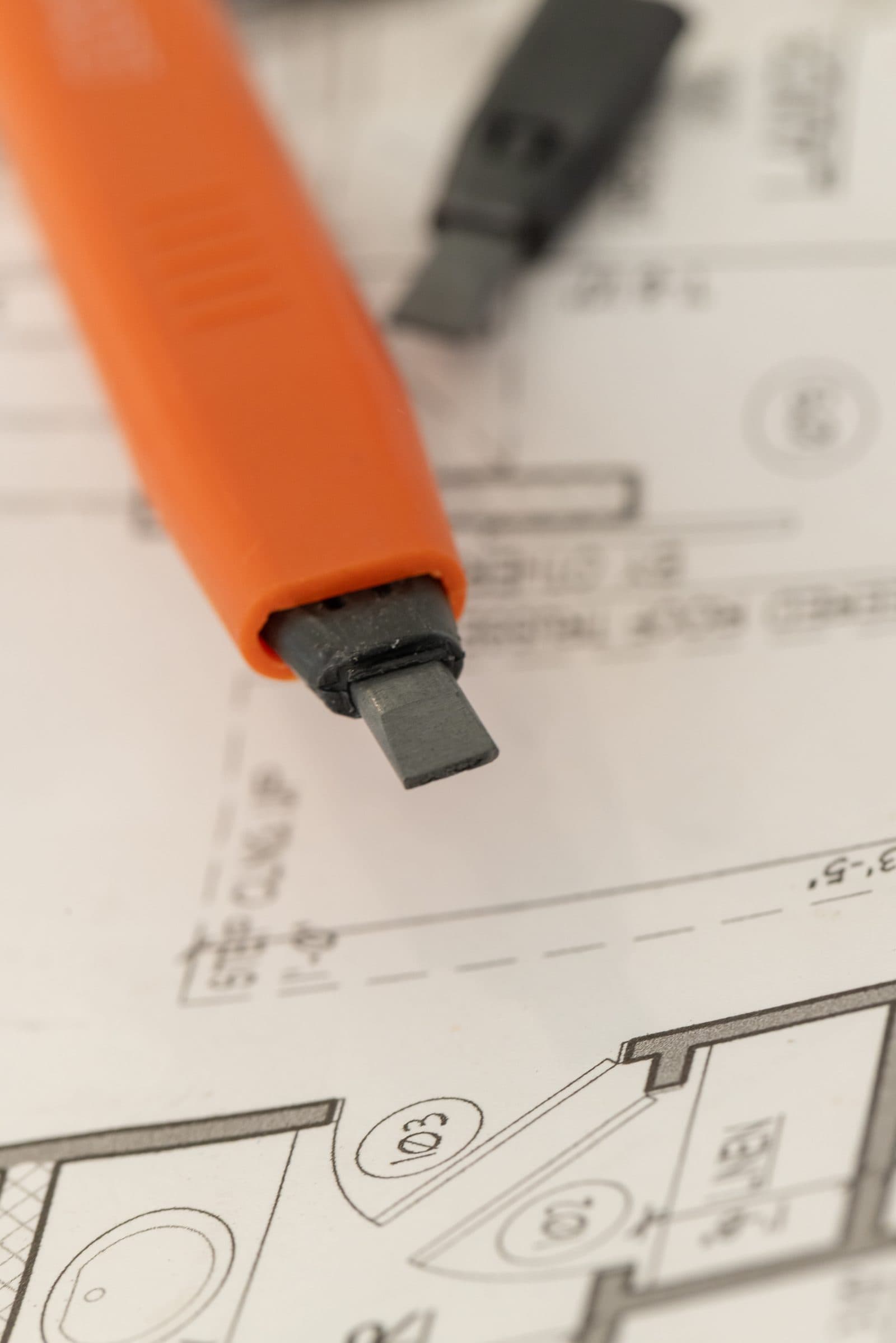 Close-up macro of the dual-tip graphite cartridge on the Swanson AlwaysSharp® pencil over a blueprint.