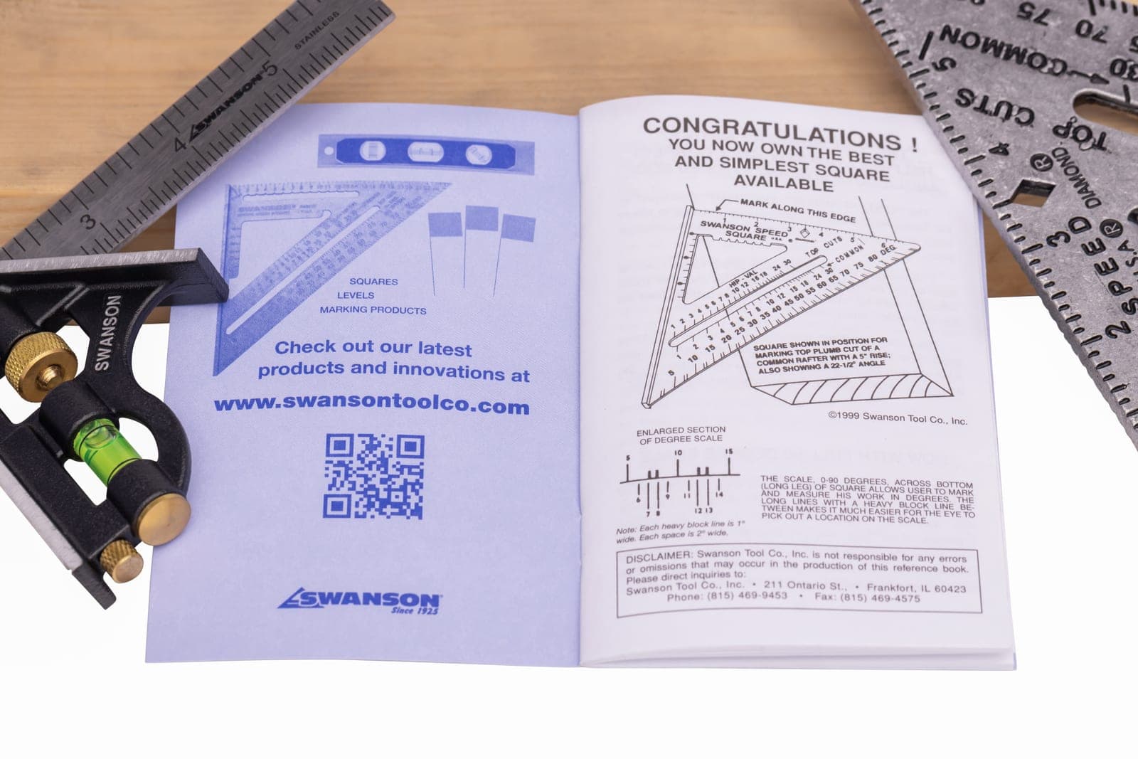 An open Swanson Blue Book of Rafter Length next to a combo square and a Speed® Square.