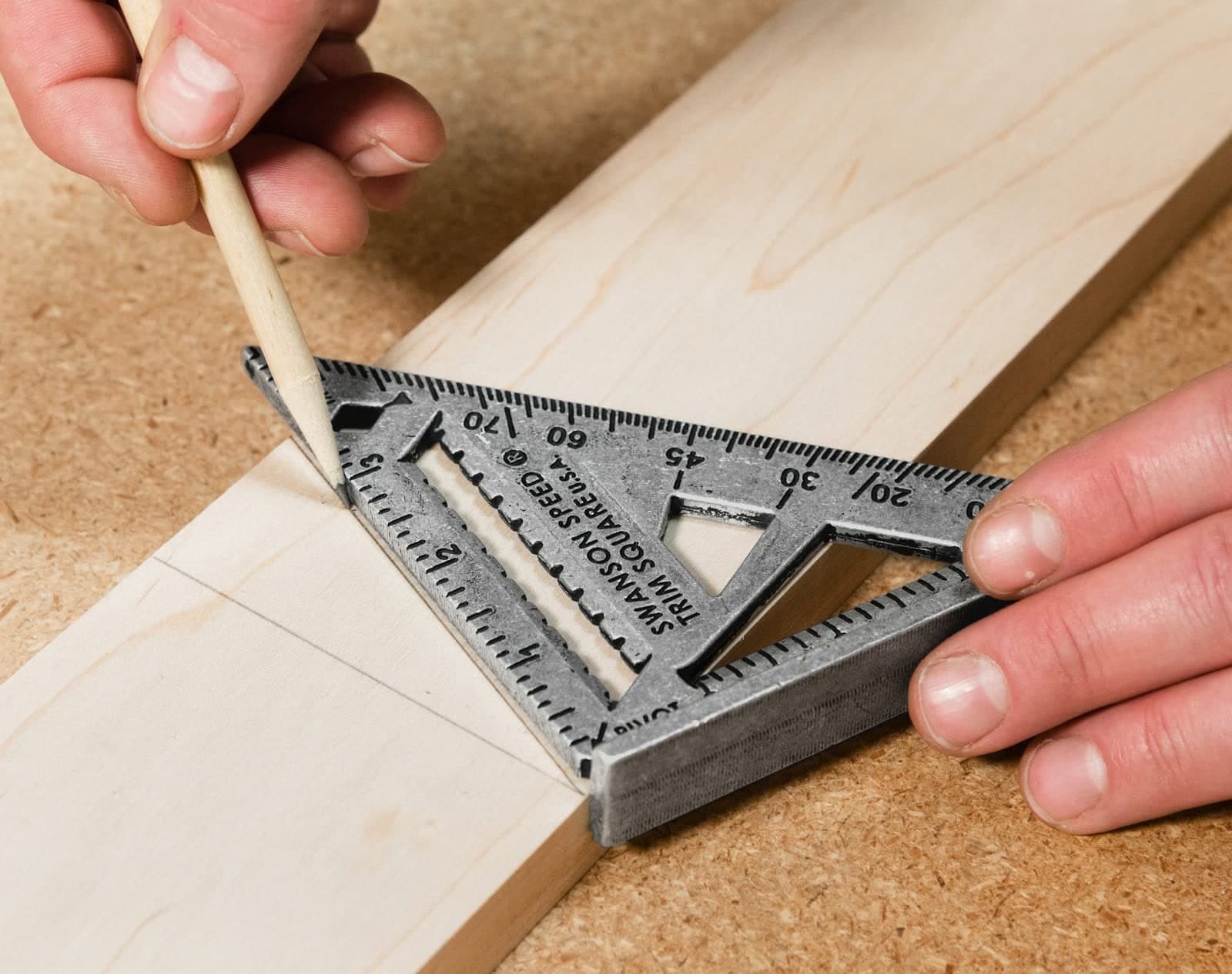 A Swanson Trim Speed® Square being used with a wooden pencil to mark a 22.5° angle on a piece of trim.