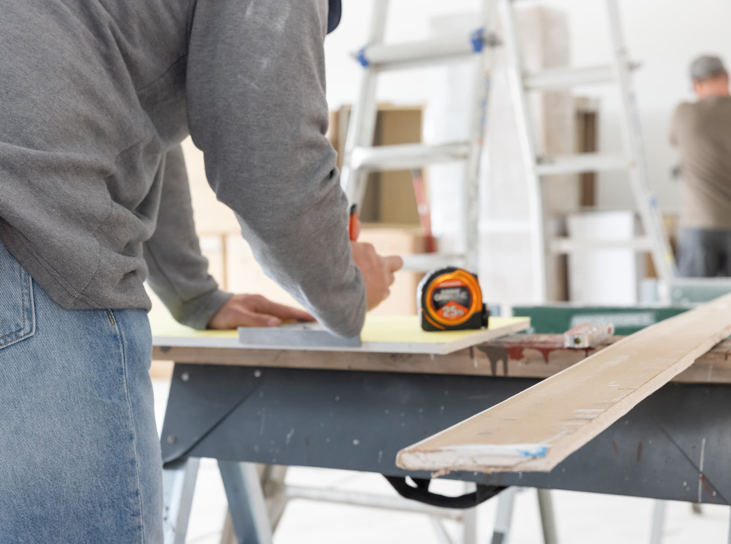 Tradesman extending the GripLine® tape across a wide gap.