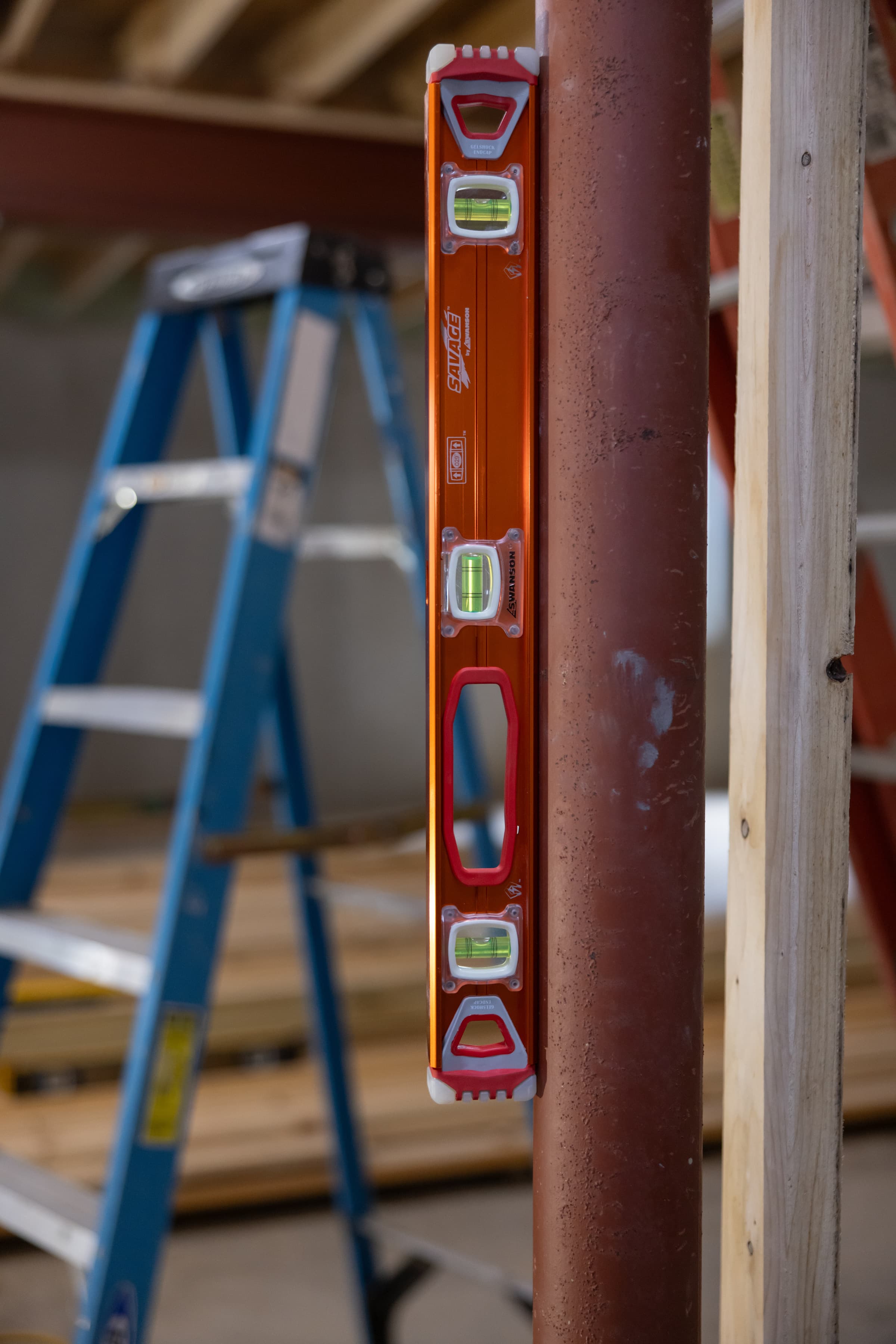A trades pro using the SVI24M SAVAGE® Magnetic I-Beam Level on a steel framing layout.