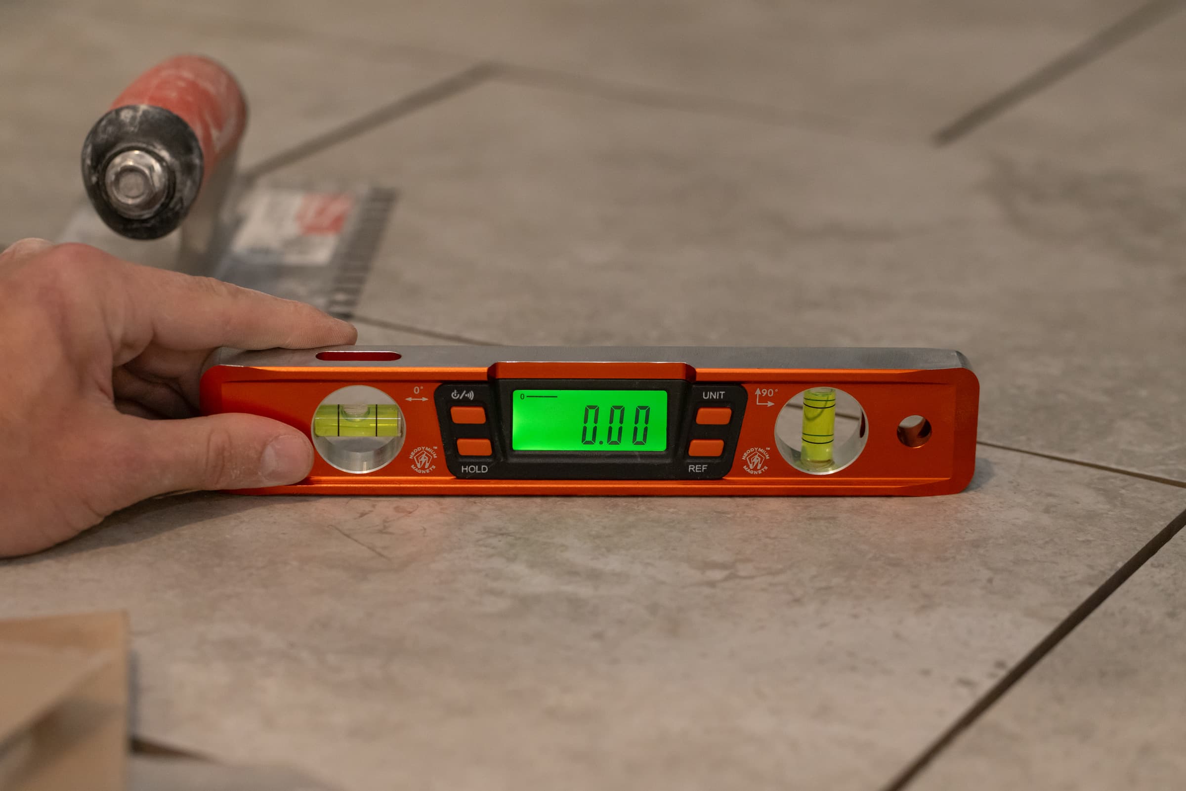 A trades pro using the Swanson Savage® 9 in. Digital Torpedo Level on a concrete pour or pitch run.