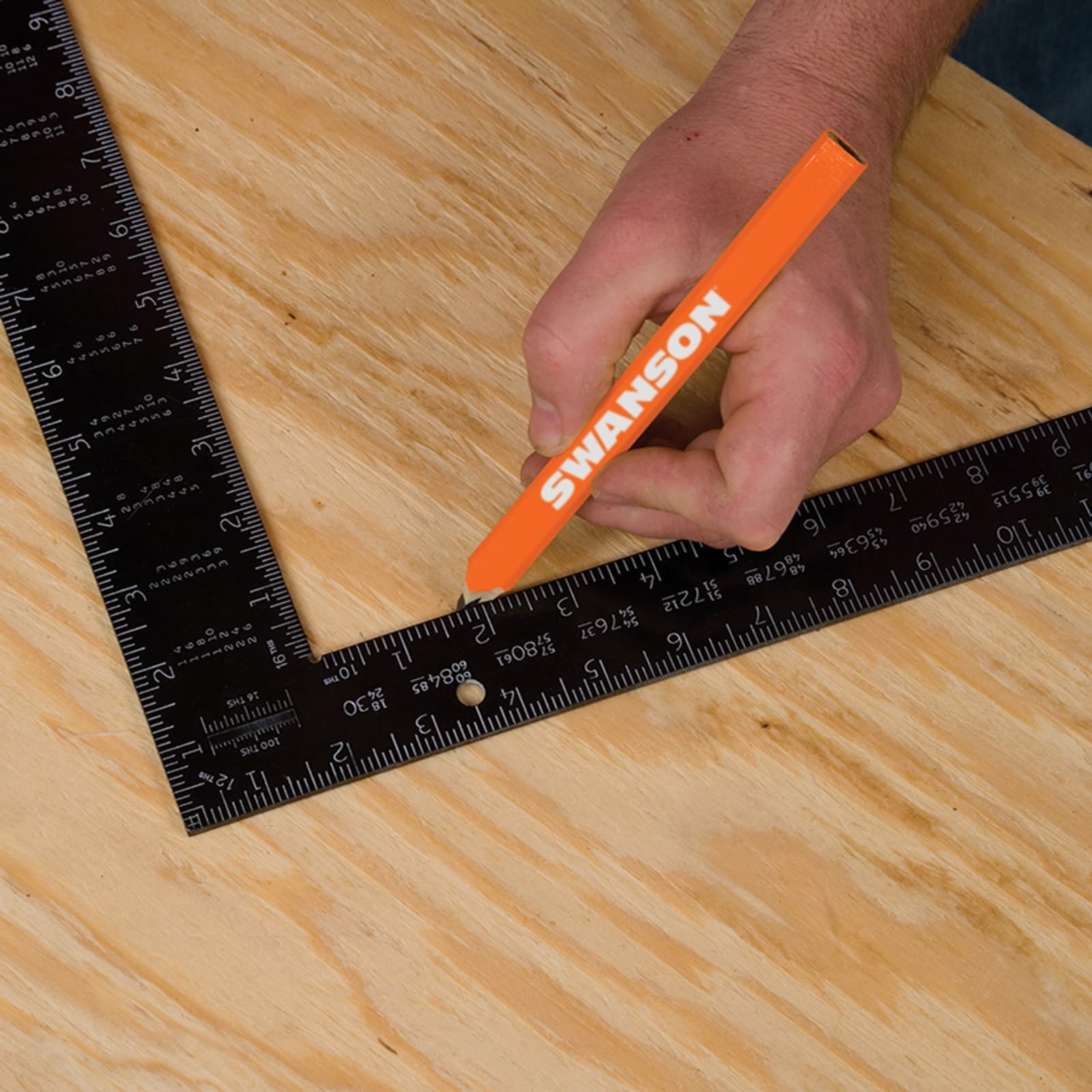 A framer using the Swanson TA126 Black Anodized Rafter Square on the job site to lay out stud spacing.