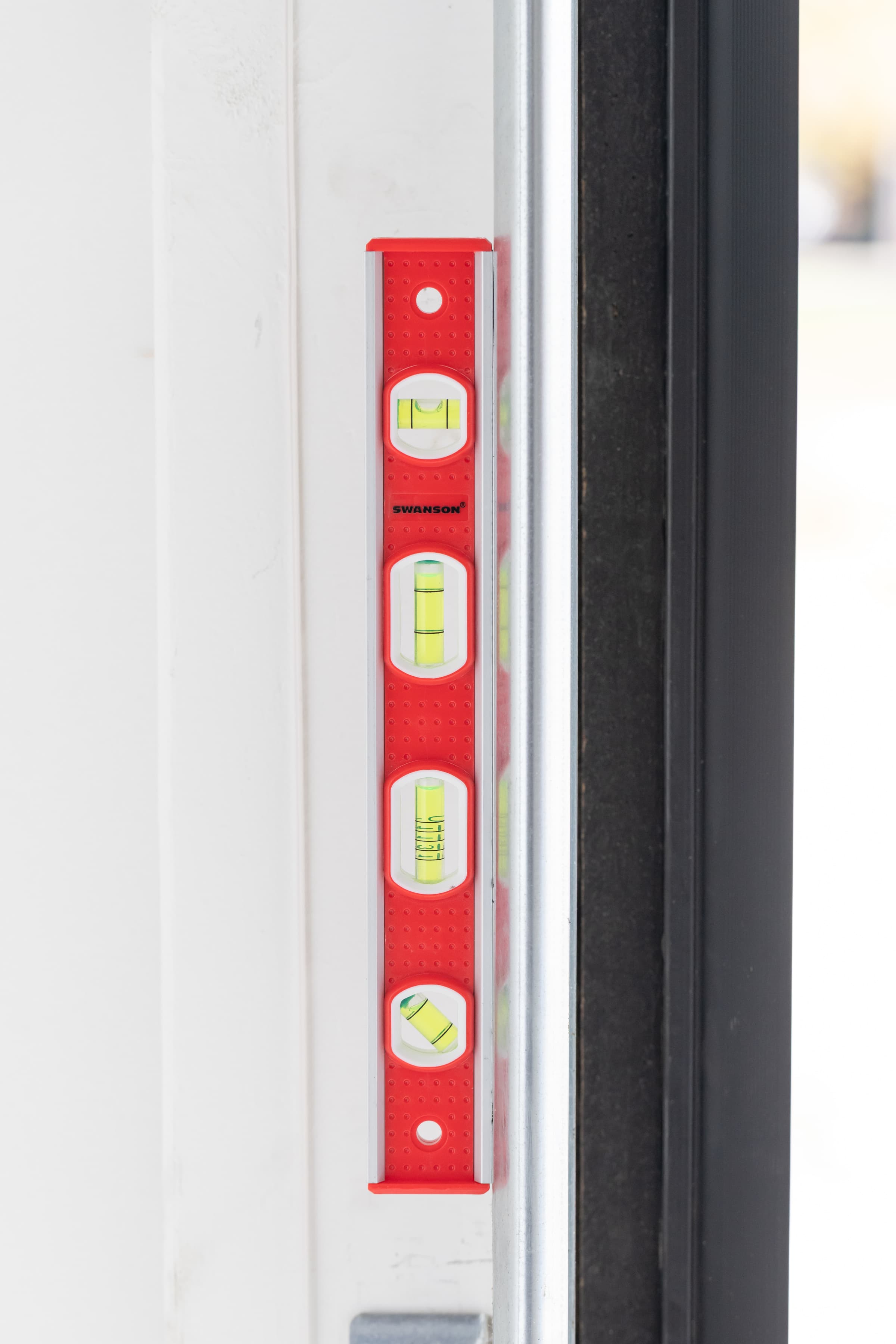A trades pro using the Swanson TBL001M Tool Box Level on a job-site application.