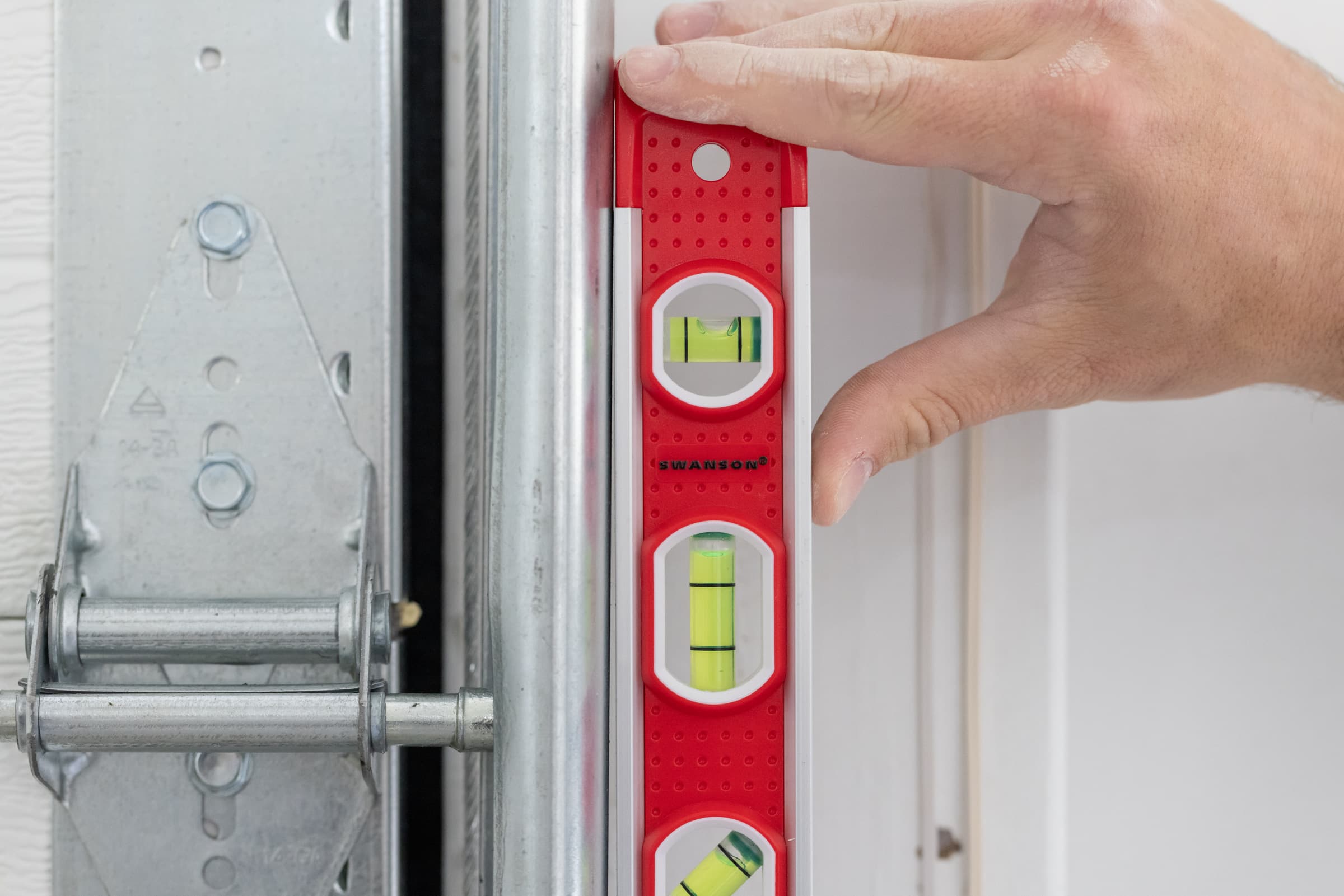 A trades pro using the Swanson TL001M Magnetic Torpedo Level on a ferrous job-site surface.