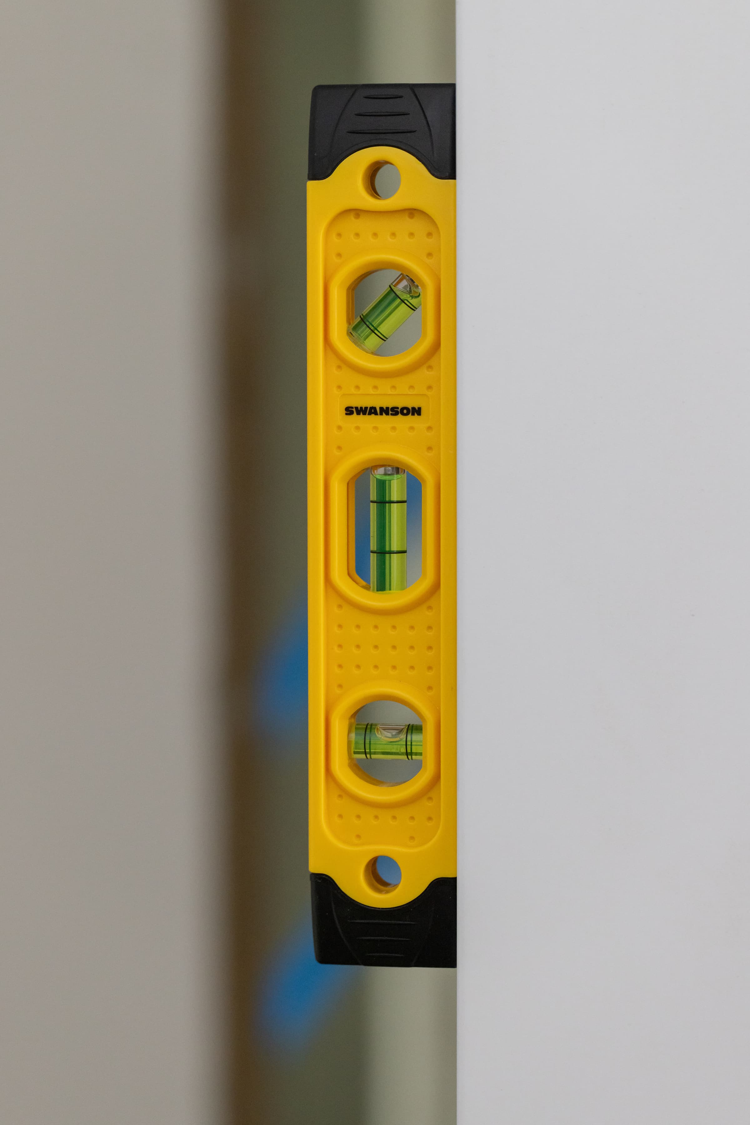 A trades pro using the Swanson Speedlite® torpedo level on a ferrous job-site surface.