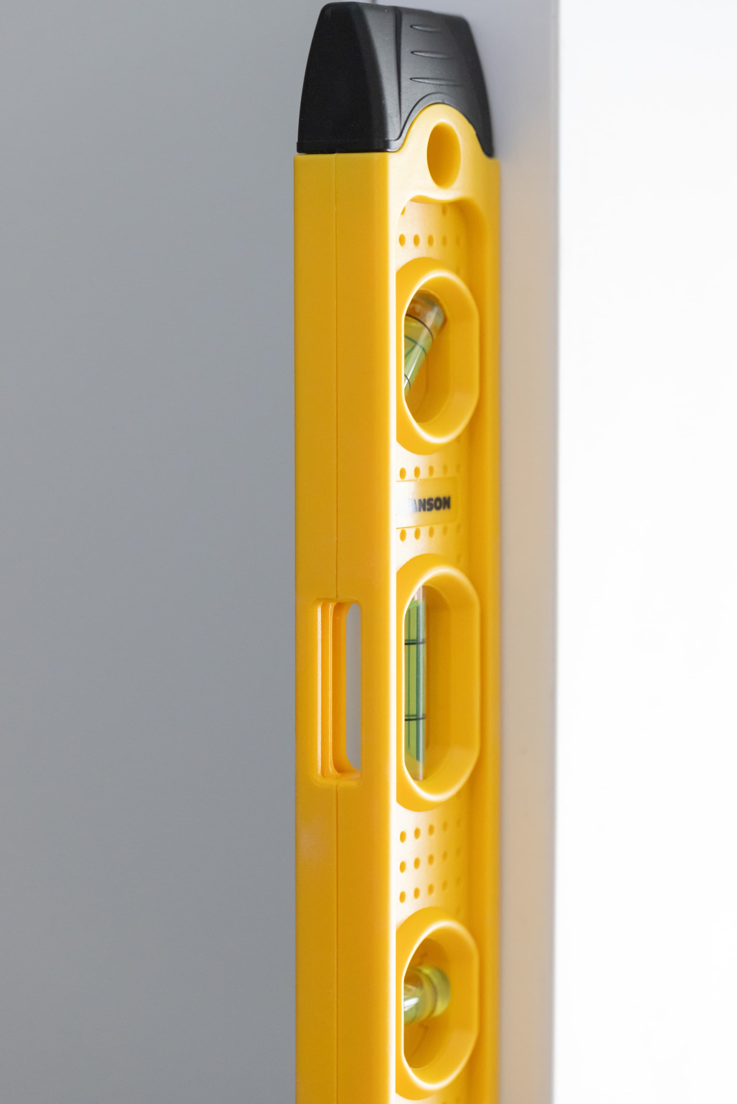 The TL021M Speedlite® torpedo level dropped on a concrete or wood surface, showing the composite frame and rubber end caps absorbing impact.