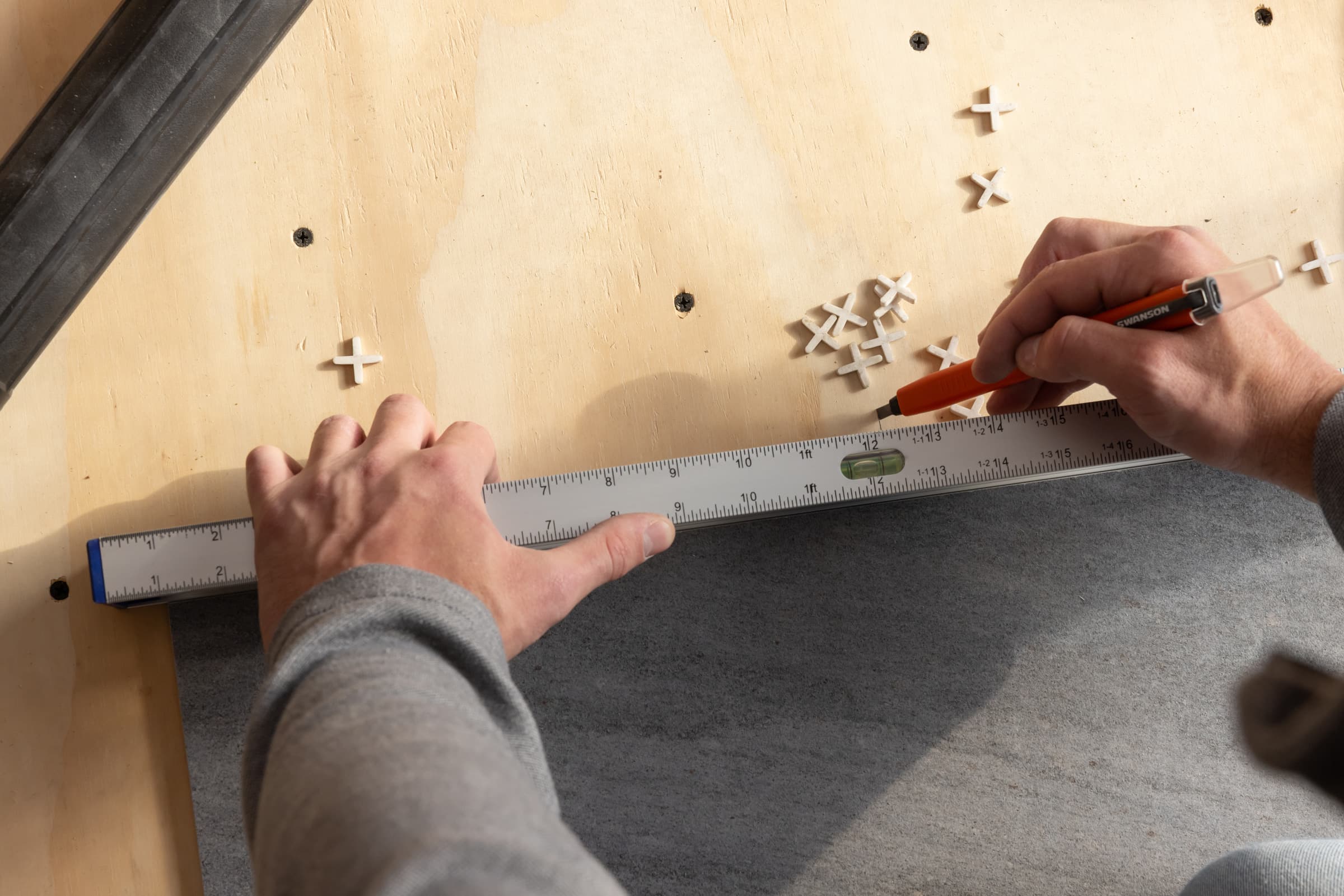A trades pro using the Swanson TRL240 Top Read Level on a job site.
