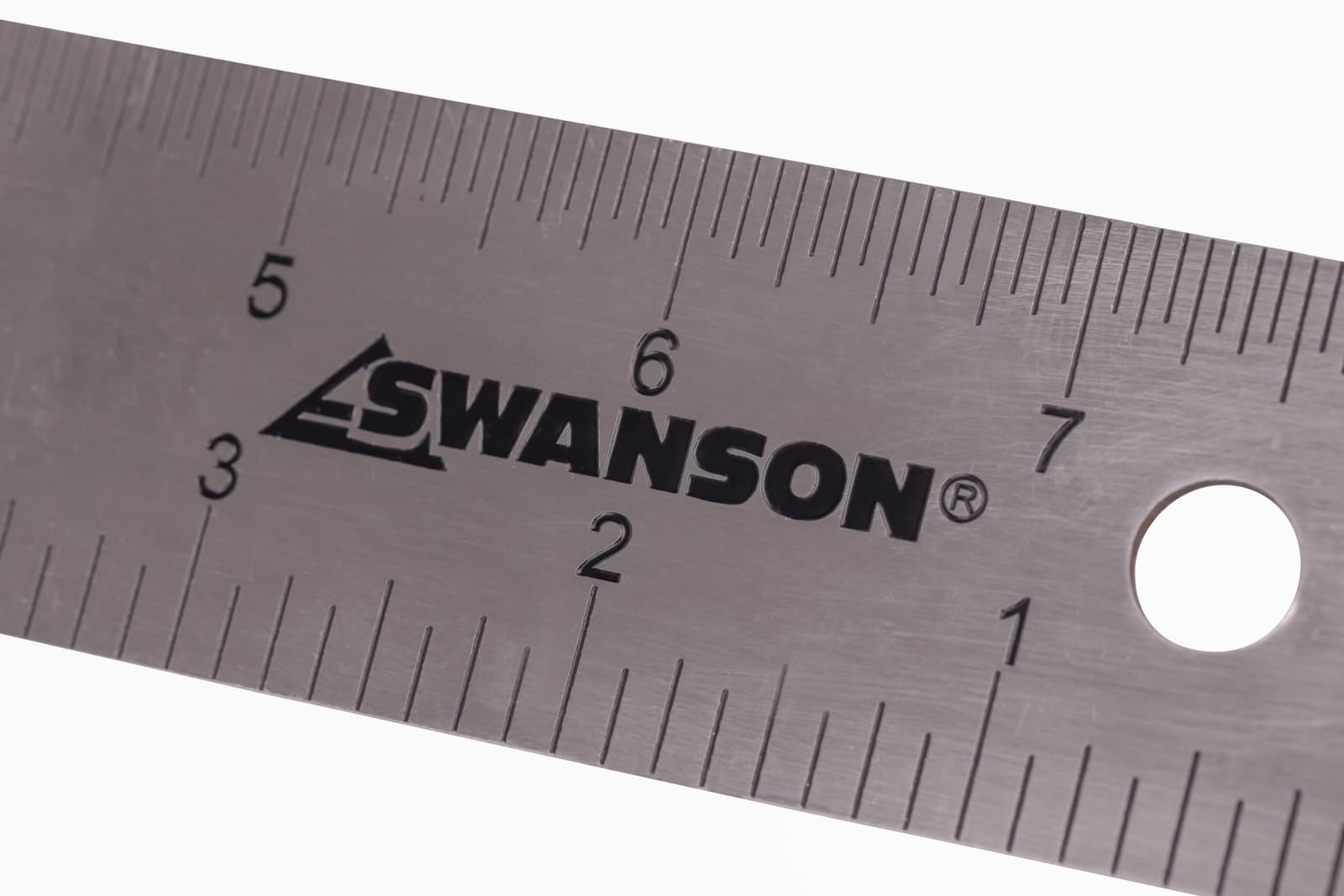 A woodworker using the Swanson TS152 to mark a square layout on a piece of stock at the bench.